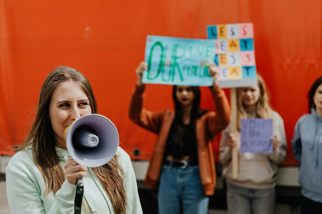 Jeunes femmes manifestant contre les violences faites aux femmes, l’une d’elles tenant un mégaphone pour faire entendre leur voix."