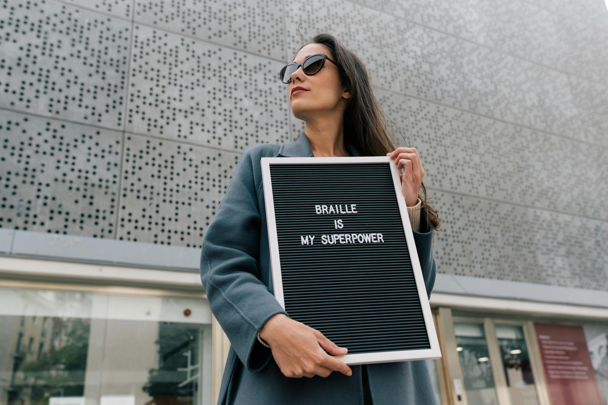 Femme confiante tenant une pancarte sur laquelle est inscrit "Vulnerable is my superpower", symbole de résilience et de libération de la parole.